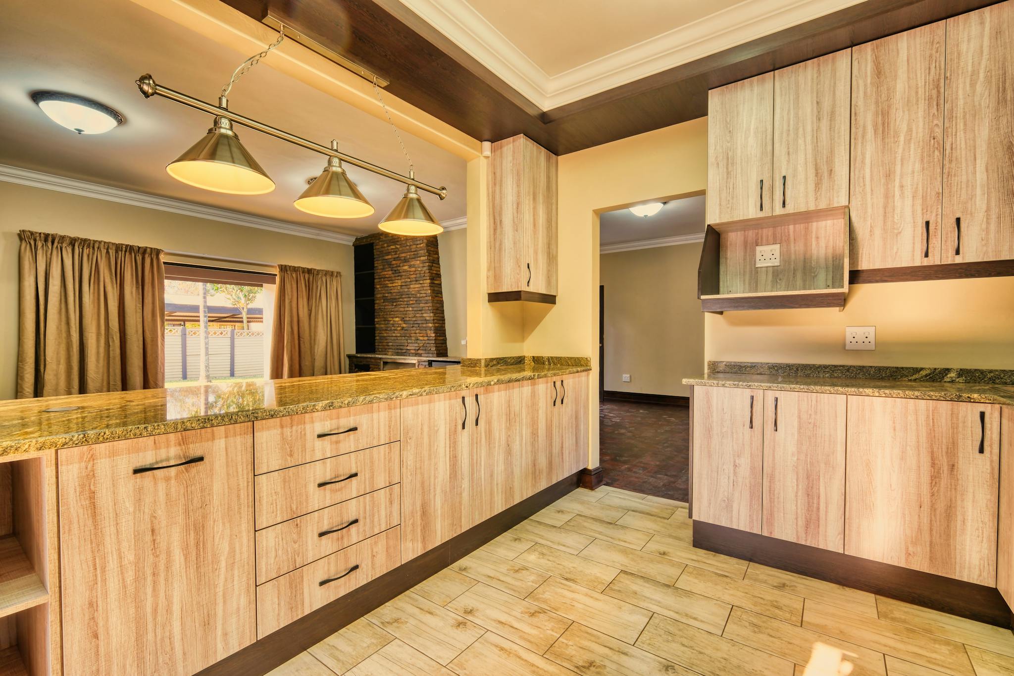 Bright kitchen interior featuring wooden cabinets and sleek lighting for a contemporary look.